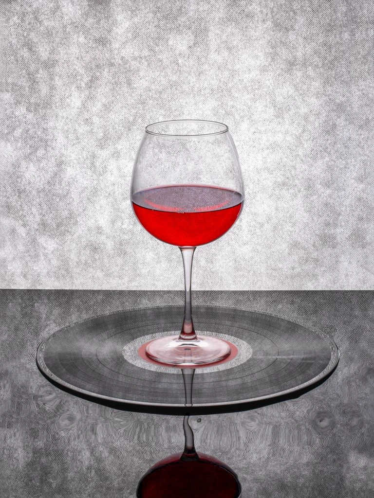 A single vintage Burgundy bottle resting on an oak cellar table