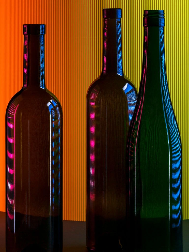 Three wine bottles on a cellar tasting bench